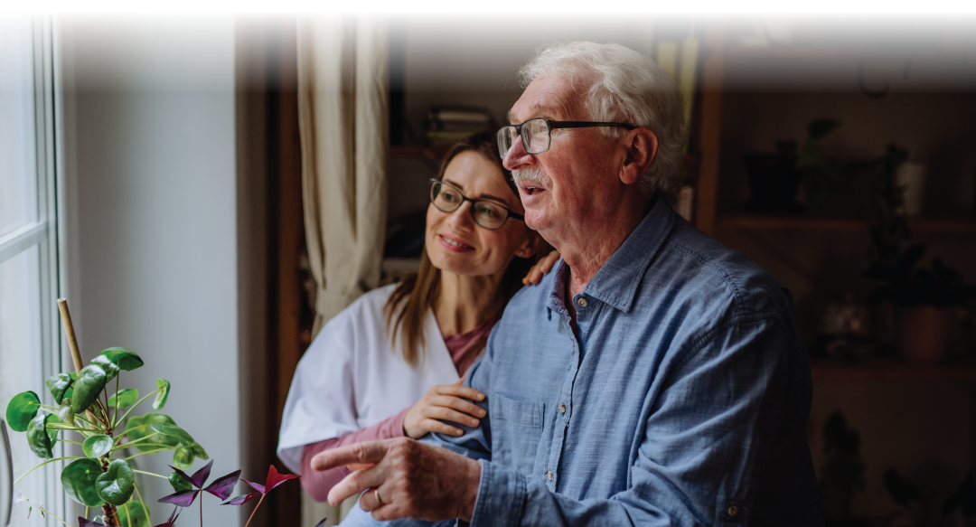 caregiver visiting senior man indoors at home, talking